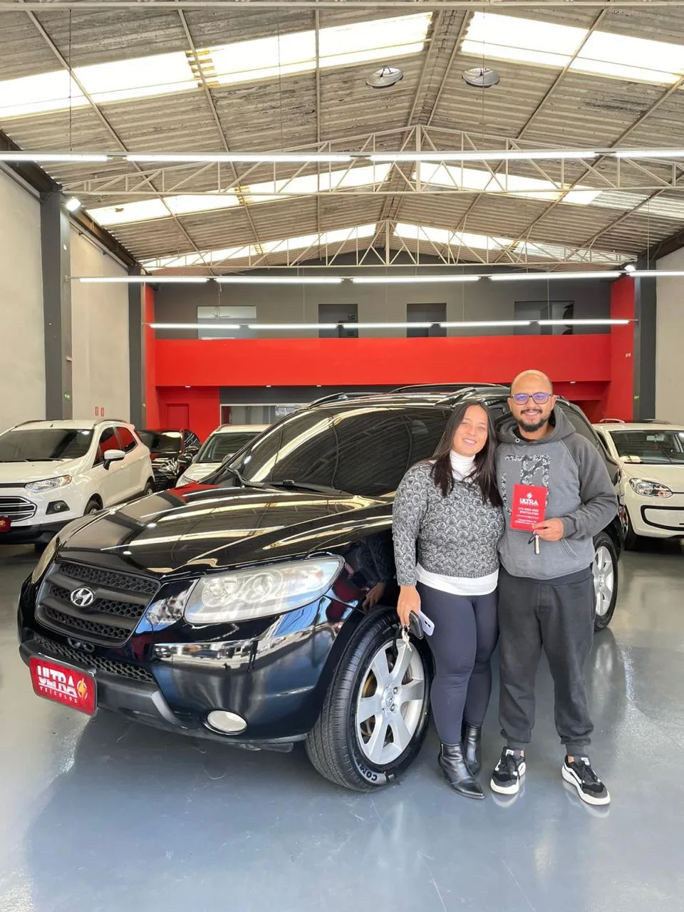 Cliente da Ultra Veículos com o carro que comprou na loja