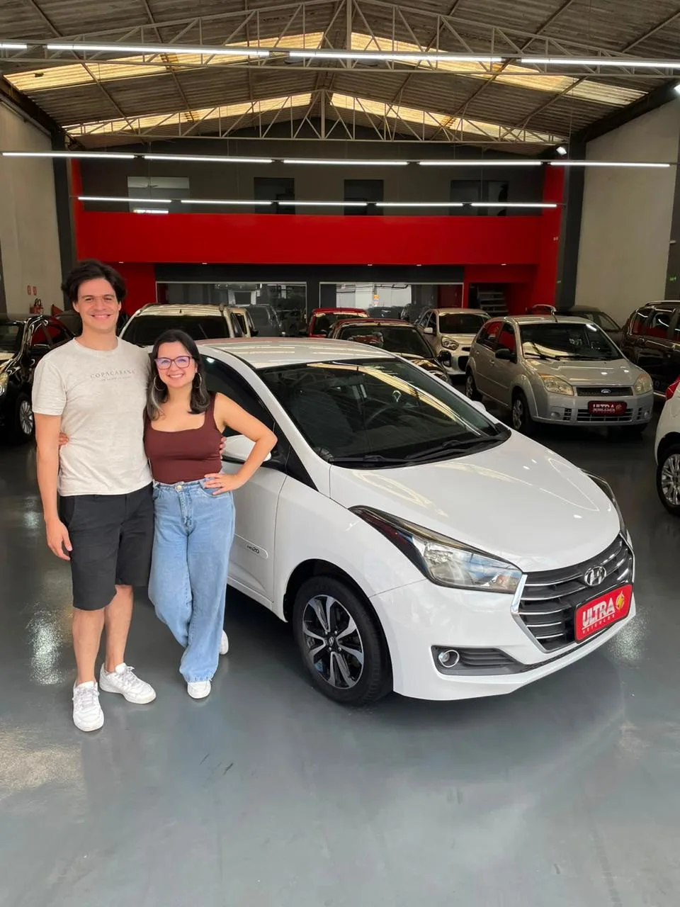 Cliente da Ultra Veículos com o carro que comprou na loja