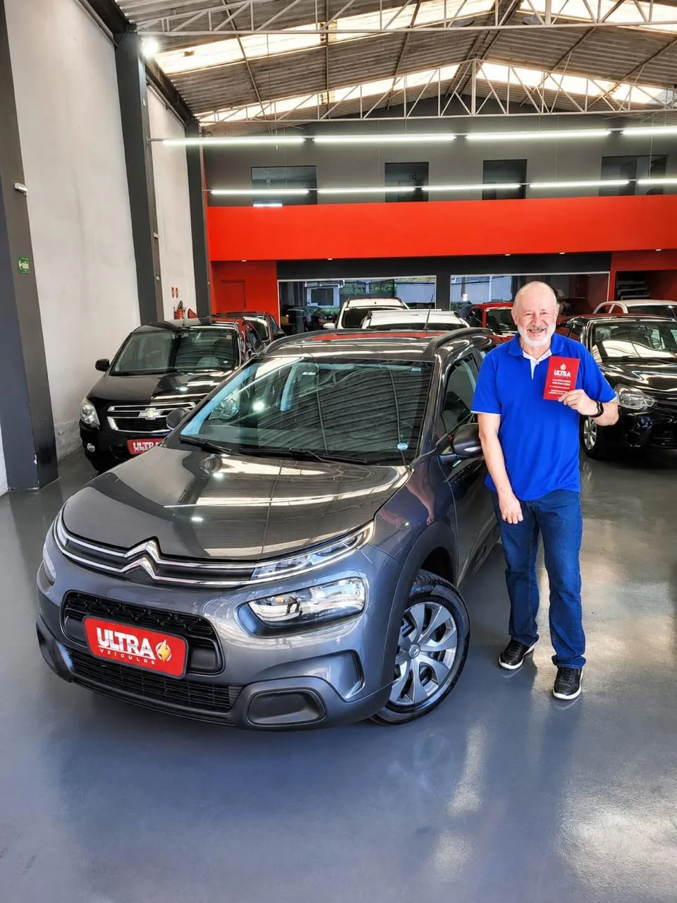 Cliente da Ultra Veículos com o carro que comprou na loja
