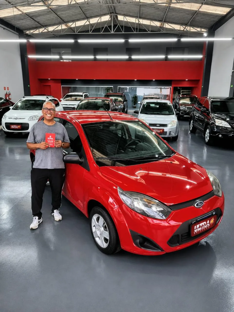 Cliente da Ultra Veículos com o carro que comprou na loja