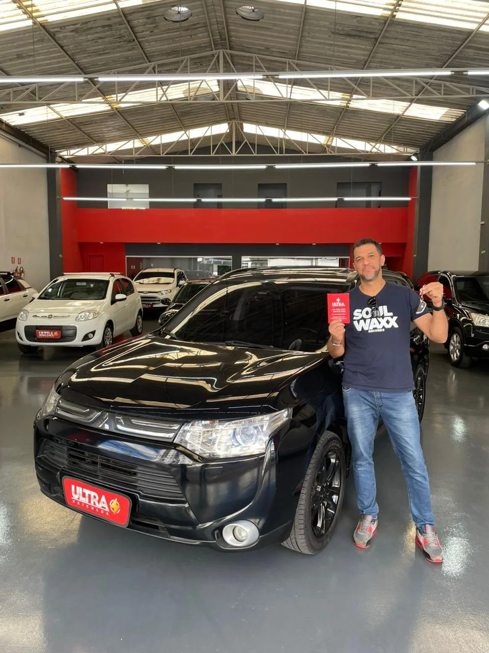 Cliente da Ultra Veículos com o carro que comprou na loja